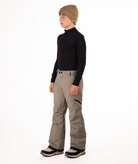 youth boy wearing a black long-sleeve shirt and beige snow pants on a white background
