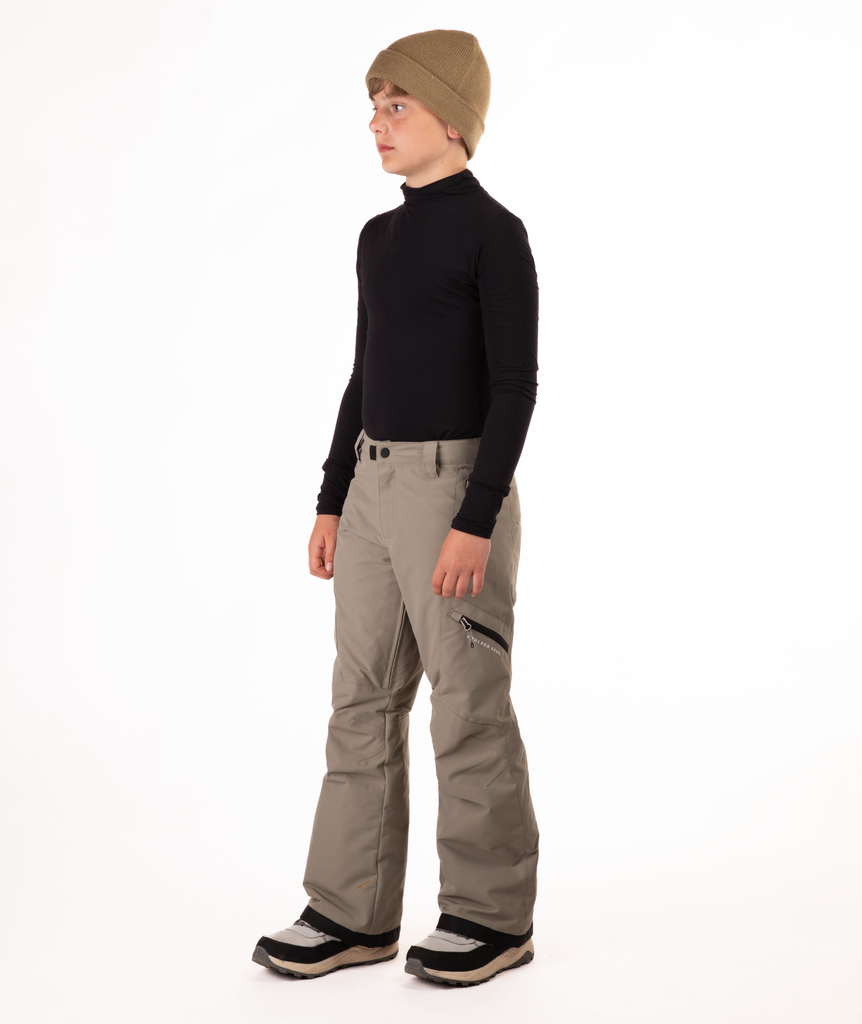 youth boy wearing a black long-sleeve shirt and beige snow pants on a white background
