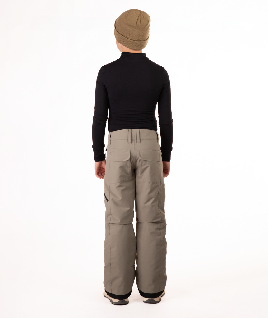 back of youth boy wearing a black long-sleeve shirt and beige snow pants on a white background