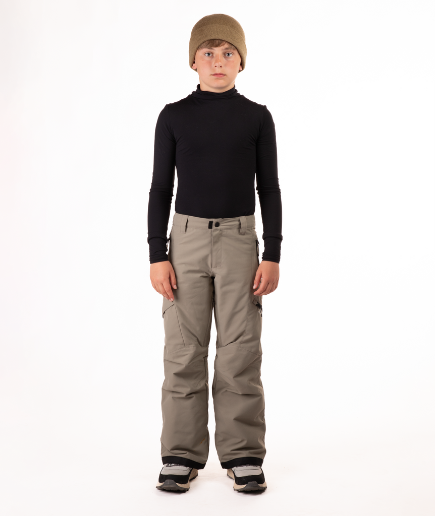 youth boy wearing a black long-sleeve shirt and beige snow pants on a white background