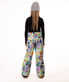 back of a Girl wearing multi colored geometric patterned snow pants and a black top on a white background