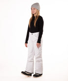 girl wearing white snow pants and a black long-sleeve top on a white background