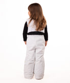 back of child wearing a white snow bib with black top on a white background