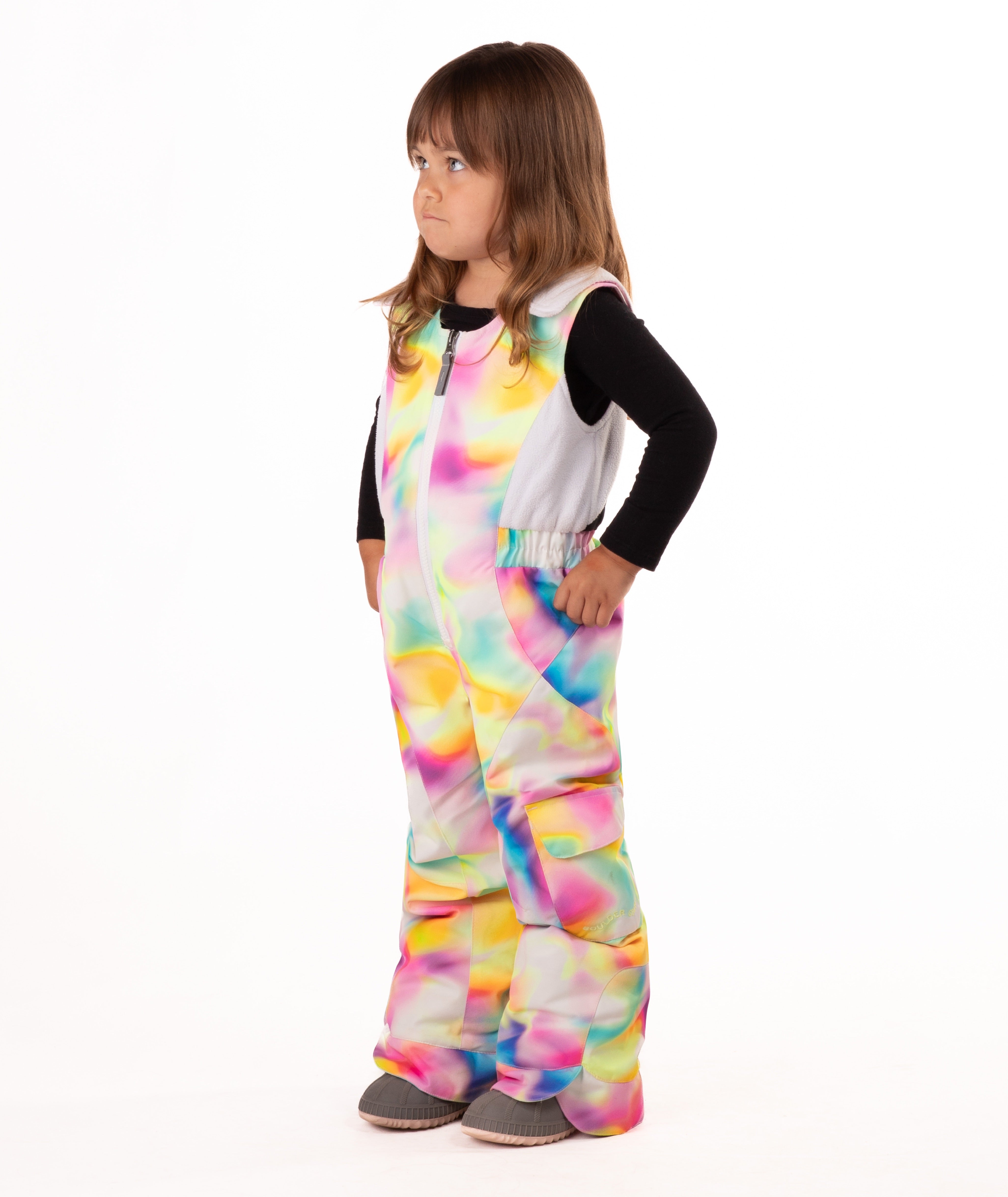 child wearing a multi color abstract print snow bib with black top on a white background