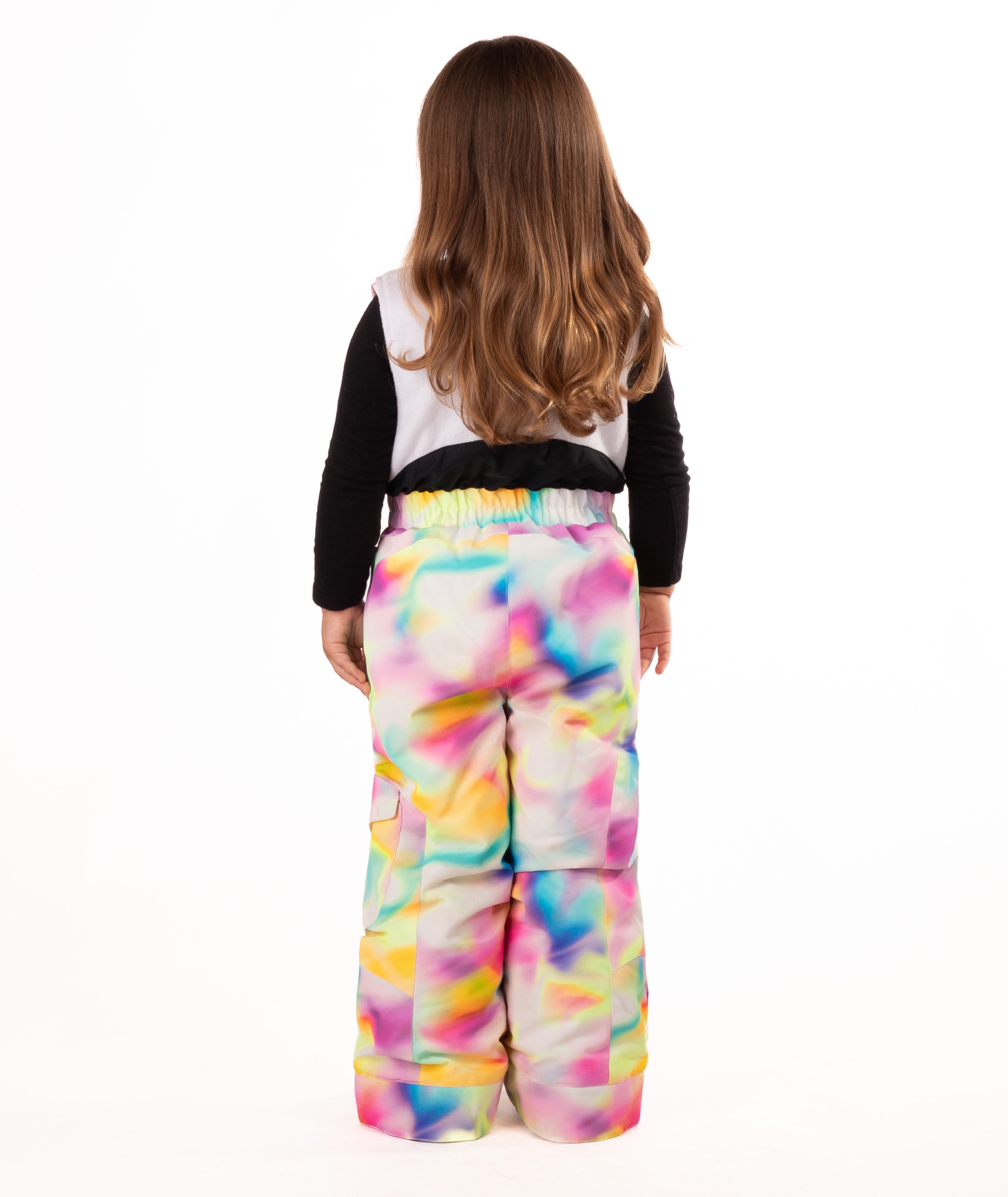 back of child wearing a multi color abstract print snow bib with black top on a white background
