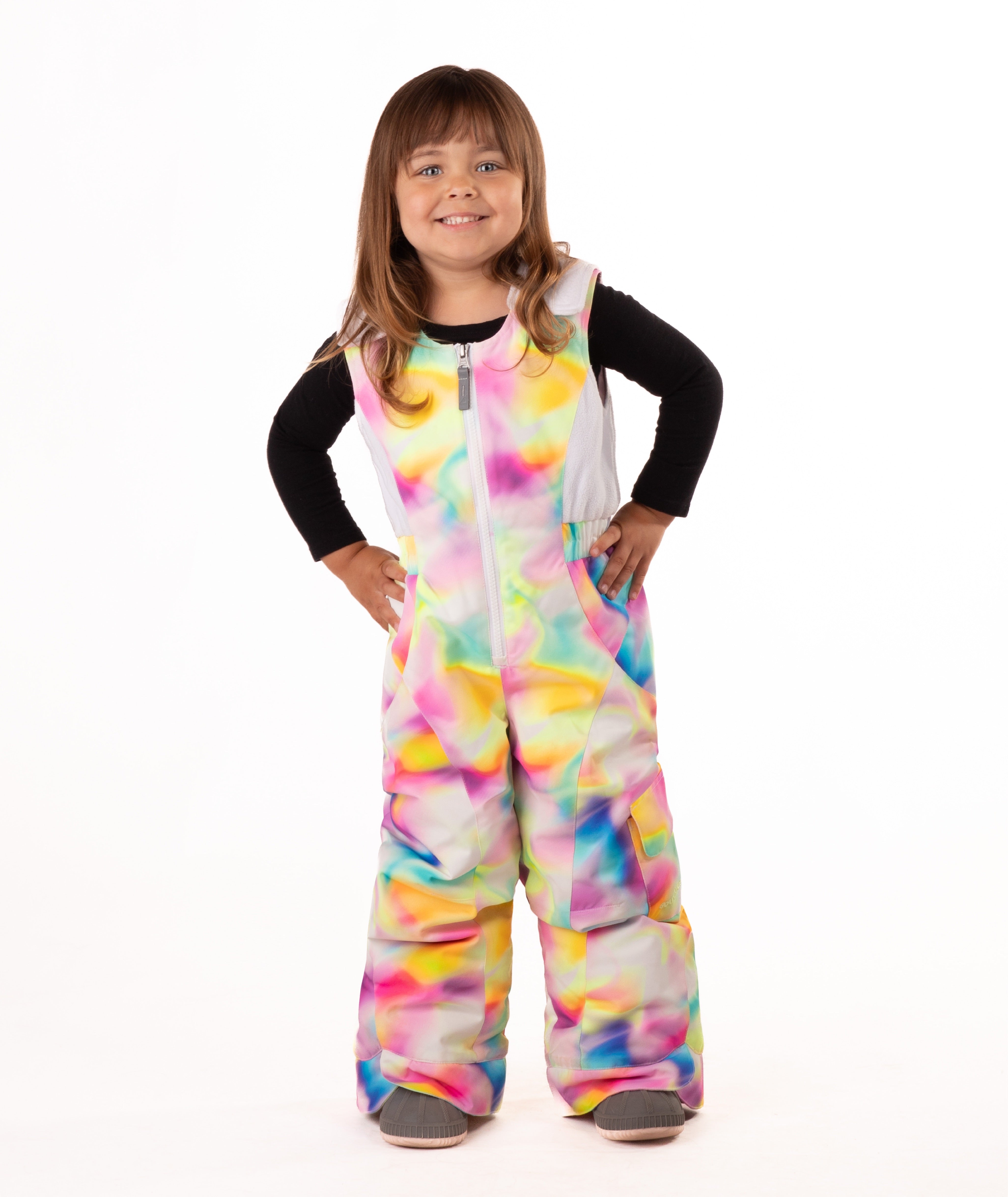 child wearing a multi color abstract print snow bib with black top on a white background
