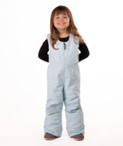 child wearing a light blue snow bib with black top on a white background