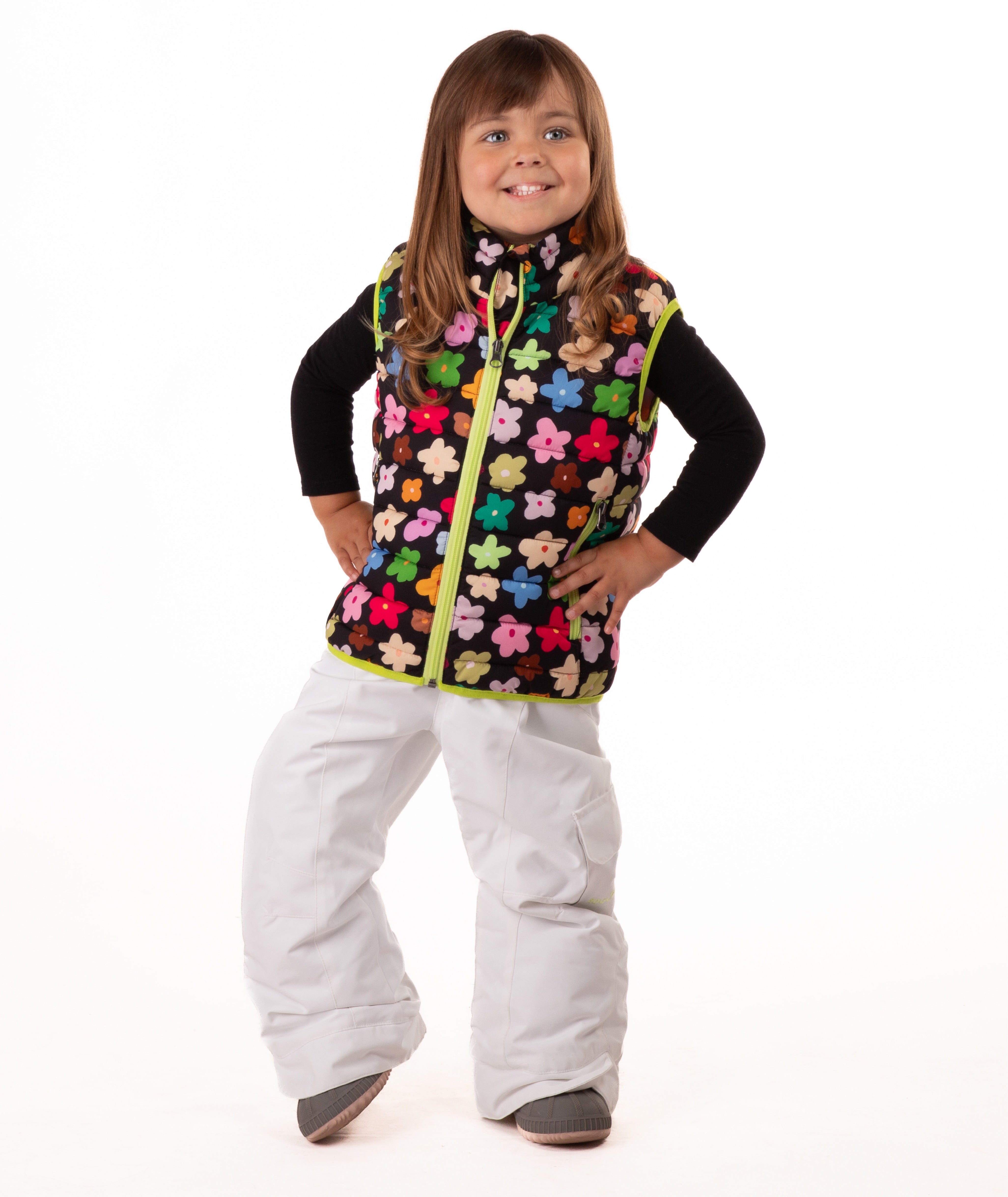 Child wearing multi colored flower print vest with yellow accents on a white background