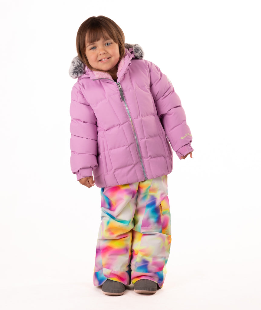 Child wearing a pink quilted puffy winter coat on a white background