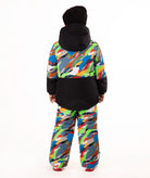 A child wearing a colorful camouflage ski jacket and matching pants with a black beanie, standing against a plain white background.