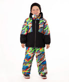 A child wearing a colorful camouflage ski jacket and matching pants with a black beanie, standing against a plain white background.