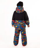 A child wearing a colorful mountain pattern ski jacket and matching pants with a black beanie, standing against a plain white background.