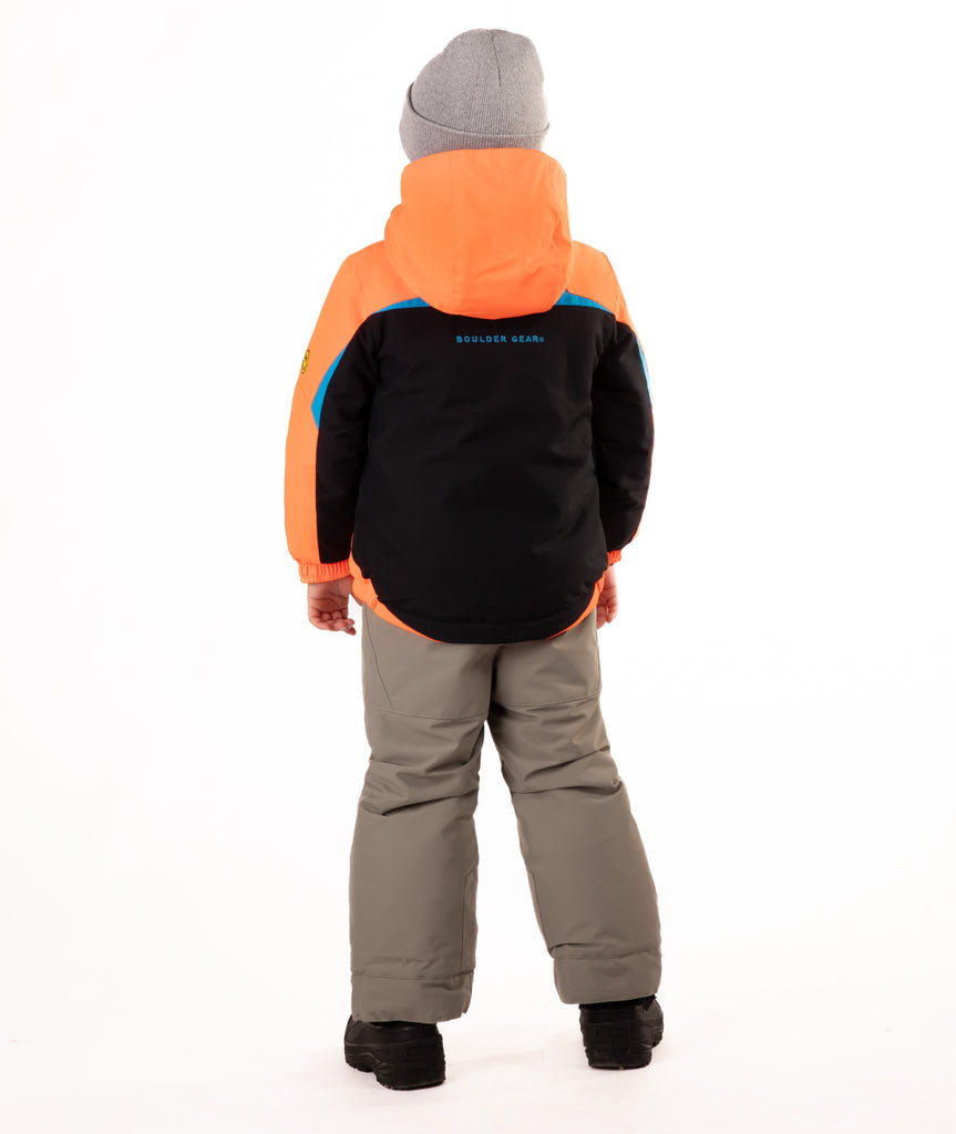 A child wearing an orange and black jacket with a visible brand logo on the back, standing against a white background.