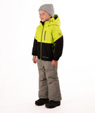 Child wearing a two-tone jacket with black  on the bottom half and bright lime yellow top half on a white background showing hand pocket and sleeve pocket detail