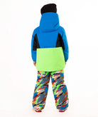 A child wearing a bright blue and green ski jacket with a black chest panel, colorful camouflage-patterned snow pants, and a black beanie, standing against a plain white background.