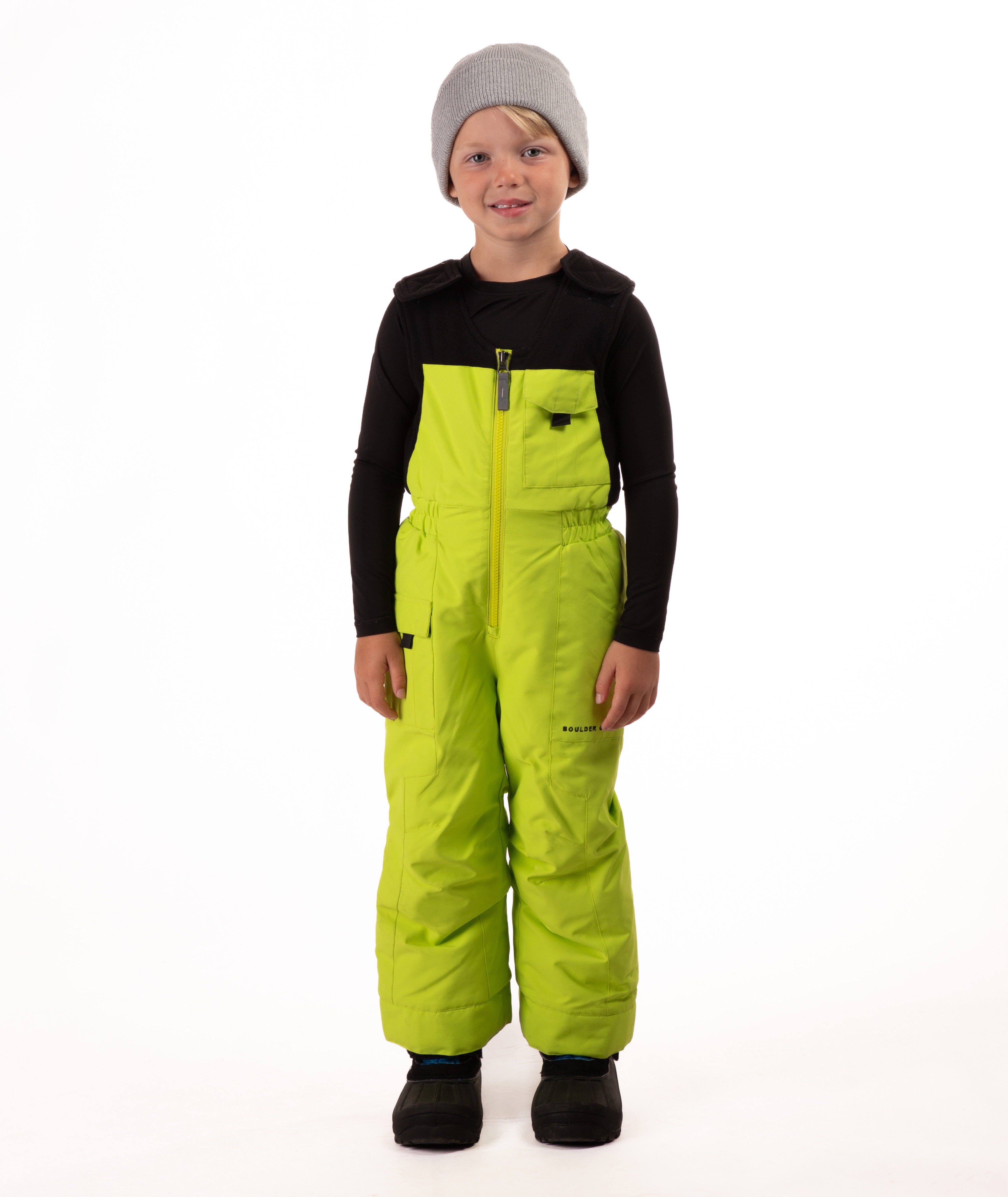 Child wearing kiwi lime snow bibs on a white background