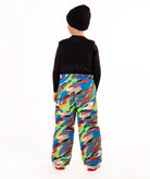 A child wearing a black knit beanie, a black long-sleeve top, and colorful camo print snow bib overalls, standing against a plain white background.