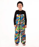 A child wearing a black knit beanie, a black long-sleeve top, and colorful camo print snow bib overalls, standing against a plain white background.