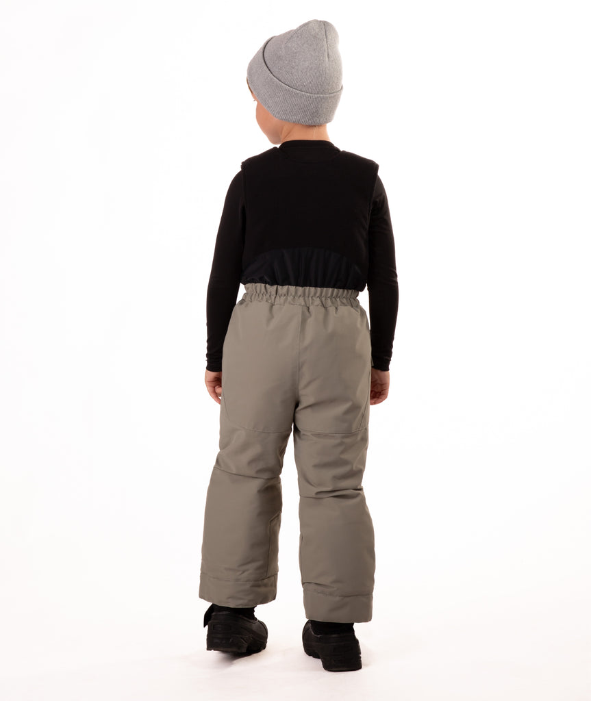 Child wearing gray snow bibs on a white background showing back of bib