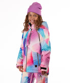 Youth girl wearing a colorful geometric print jacket on a white background