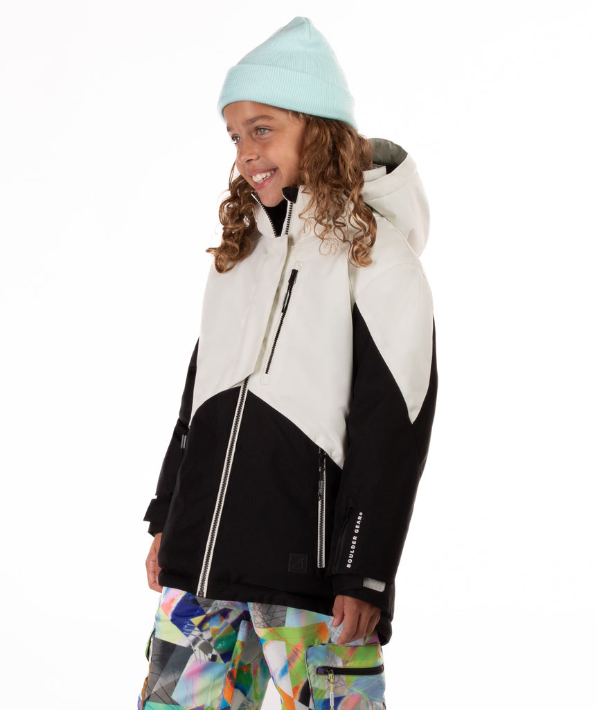Youth girl wearing a black and white jacket with contrasting zippers on a white background