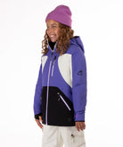 Child wearing a colorful a purple, white, and black jacket with a white background