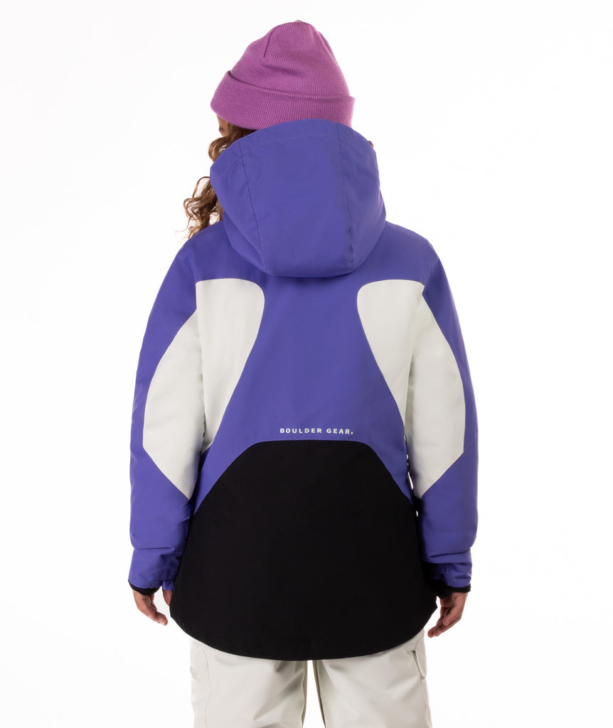 Child wearing a colorful a purple, white, and black jacket with a white background