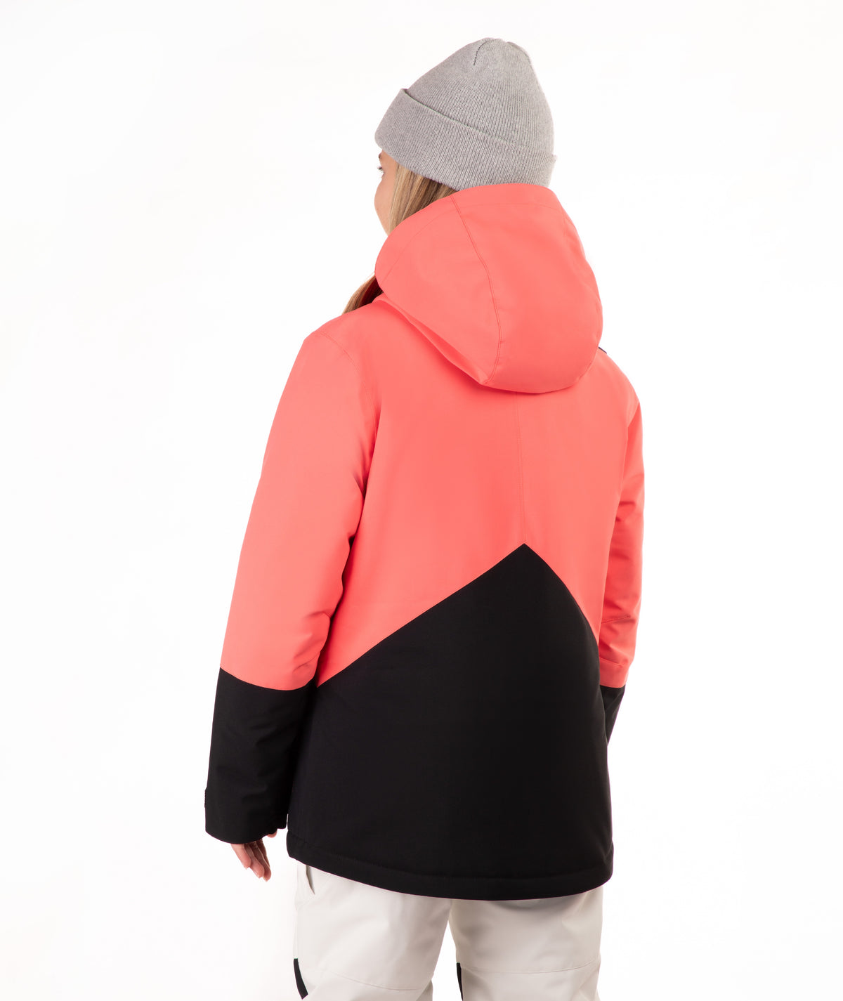 A person shown from the back wearing a color-blocked hooded jacket with a coral pink upper section and black lower section, paired with a gray beanie and light pants, against a plain white background.