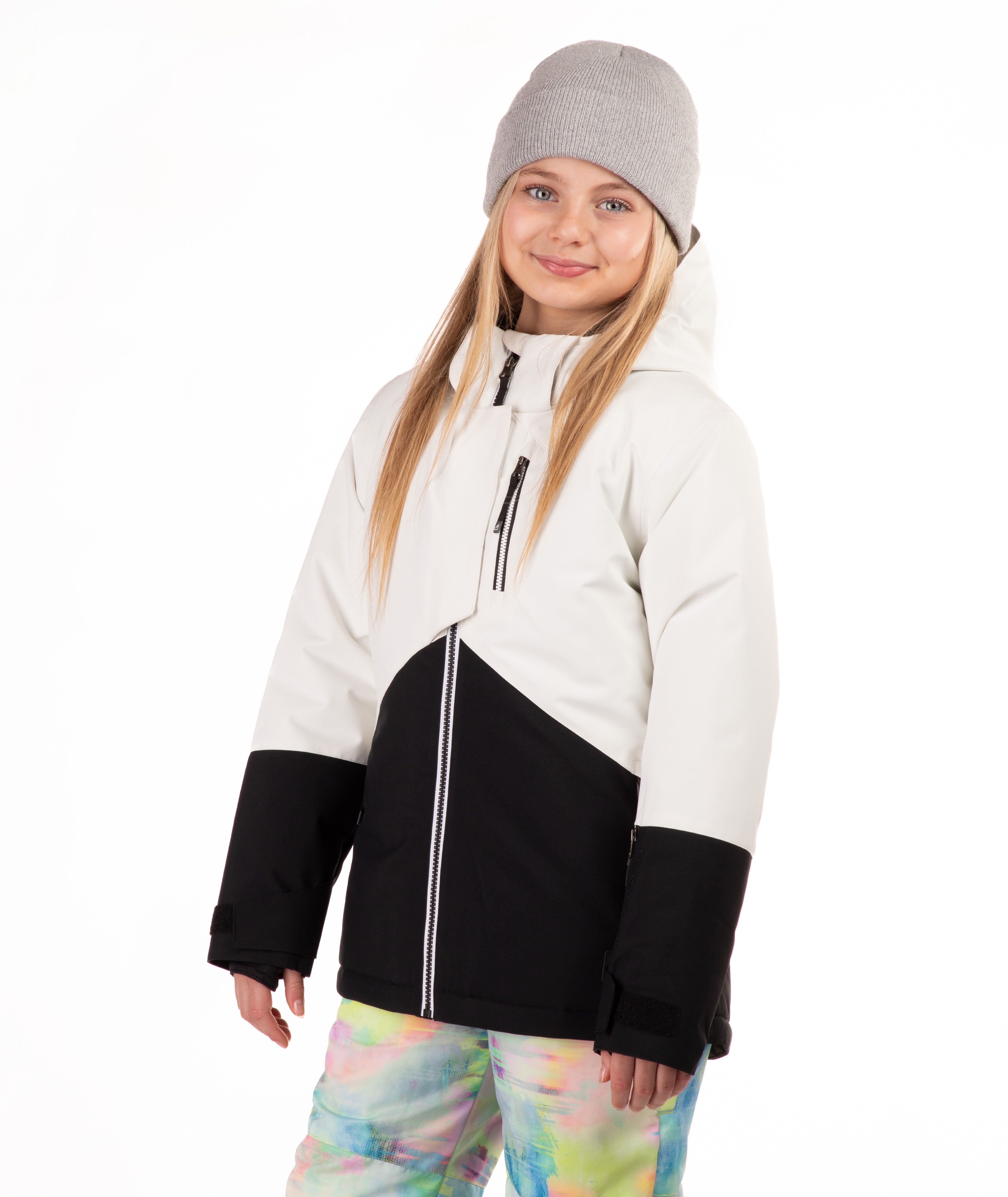 Child wearing a white and black jacket with colorful pants on a white background