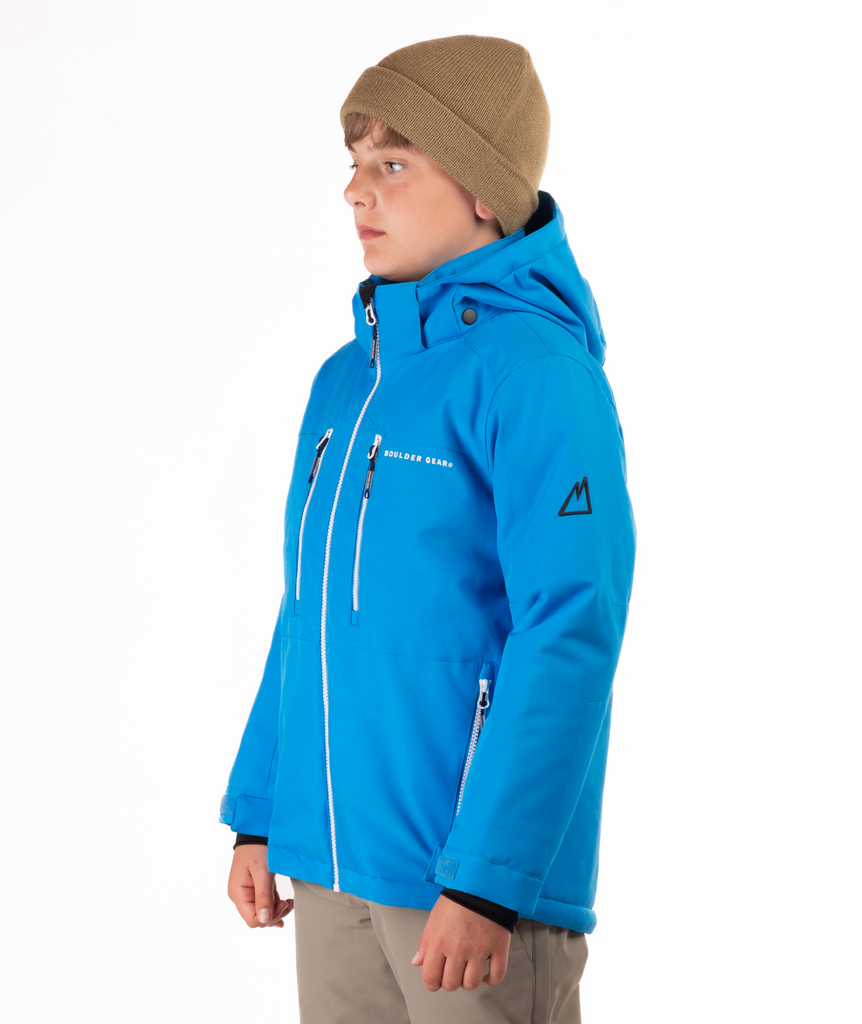 Youth boy wearing a blue jacket with white zippers and a Boulder Gear brand logo on a white background