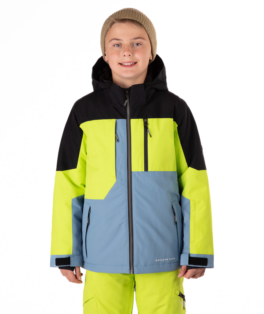 Youth boy wearing a colorful jacket with black, green, and blue sections on a white background