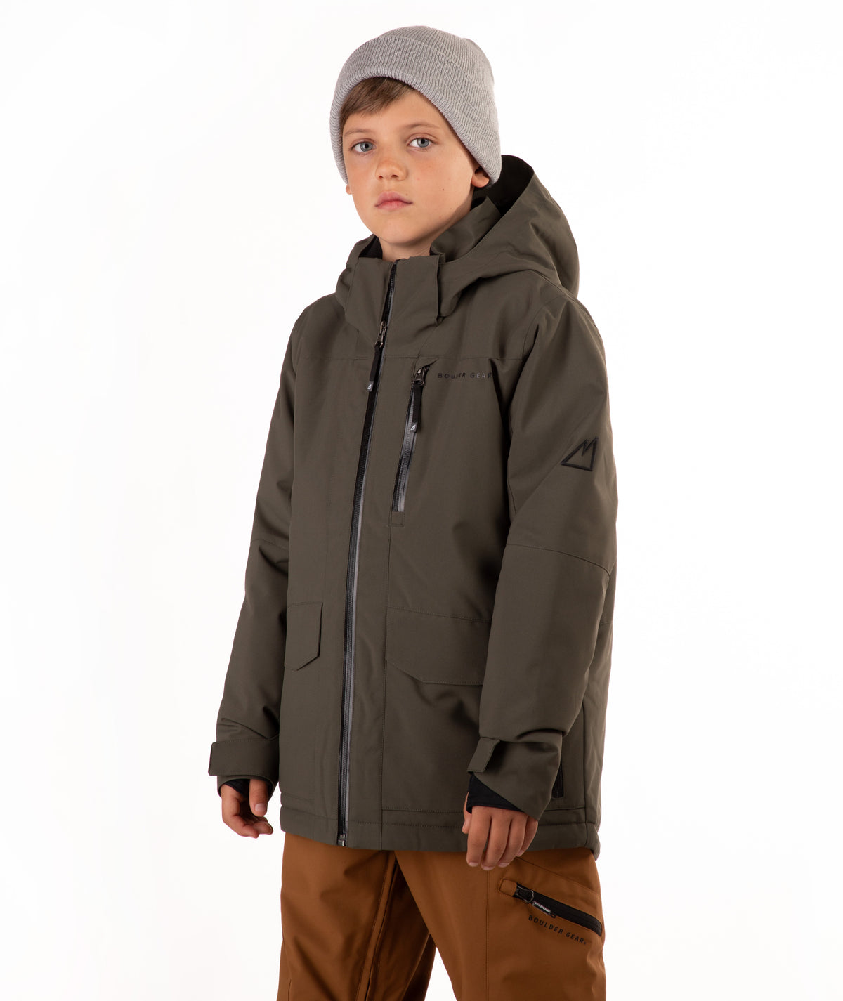A child wearing a dark olive green hooded snowboard jacket, brown pants, and a gray beanie, standing against a plain white background.