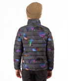 back of youth boy wearing a multi colored abstract patterned puffer jacket on a white background