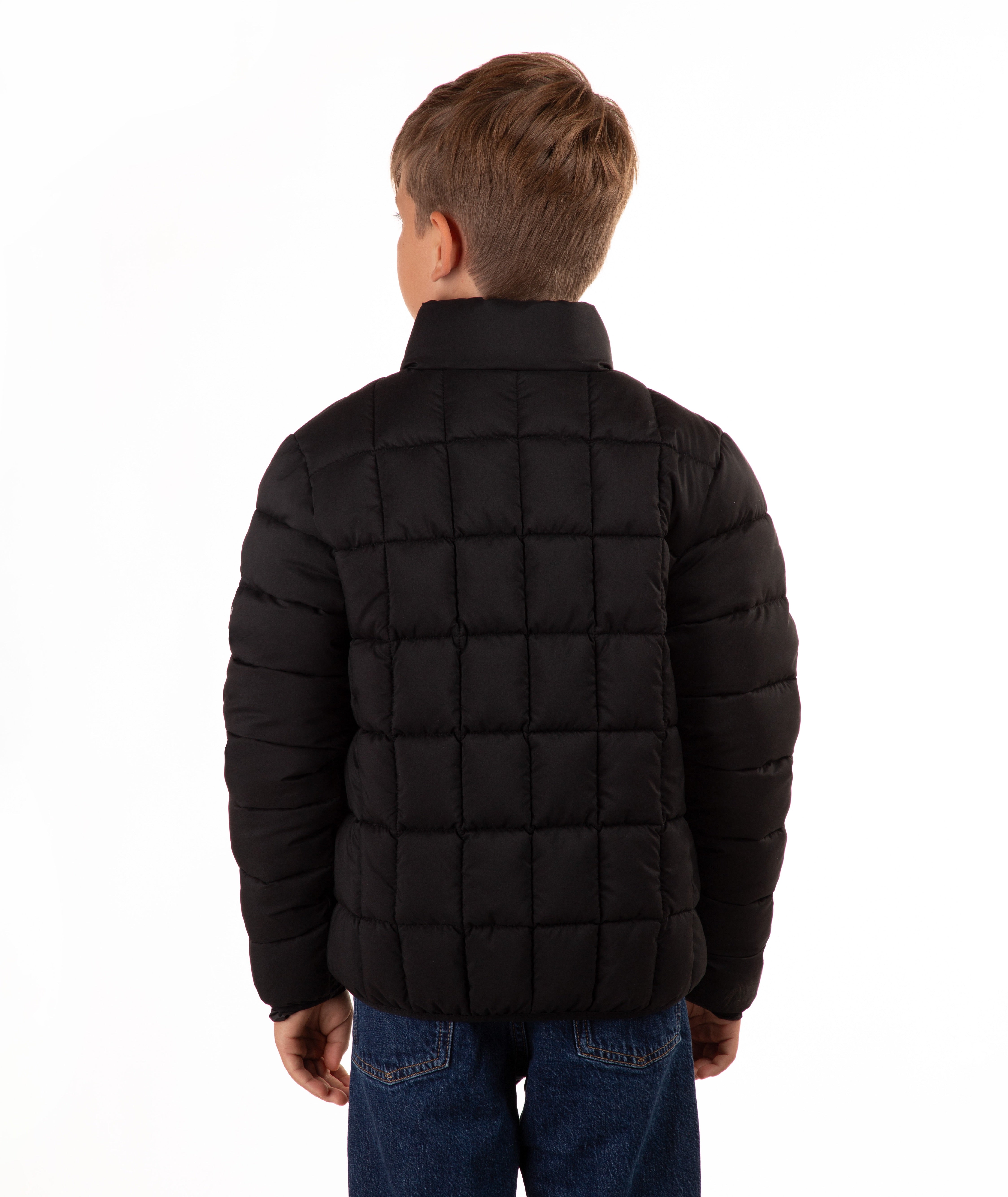 A child viewed from the back wearing a black quilted puffer jacket and blue jeans against a plain white background.