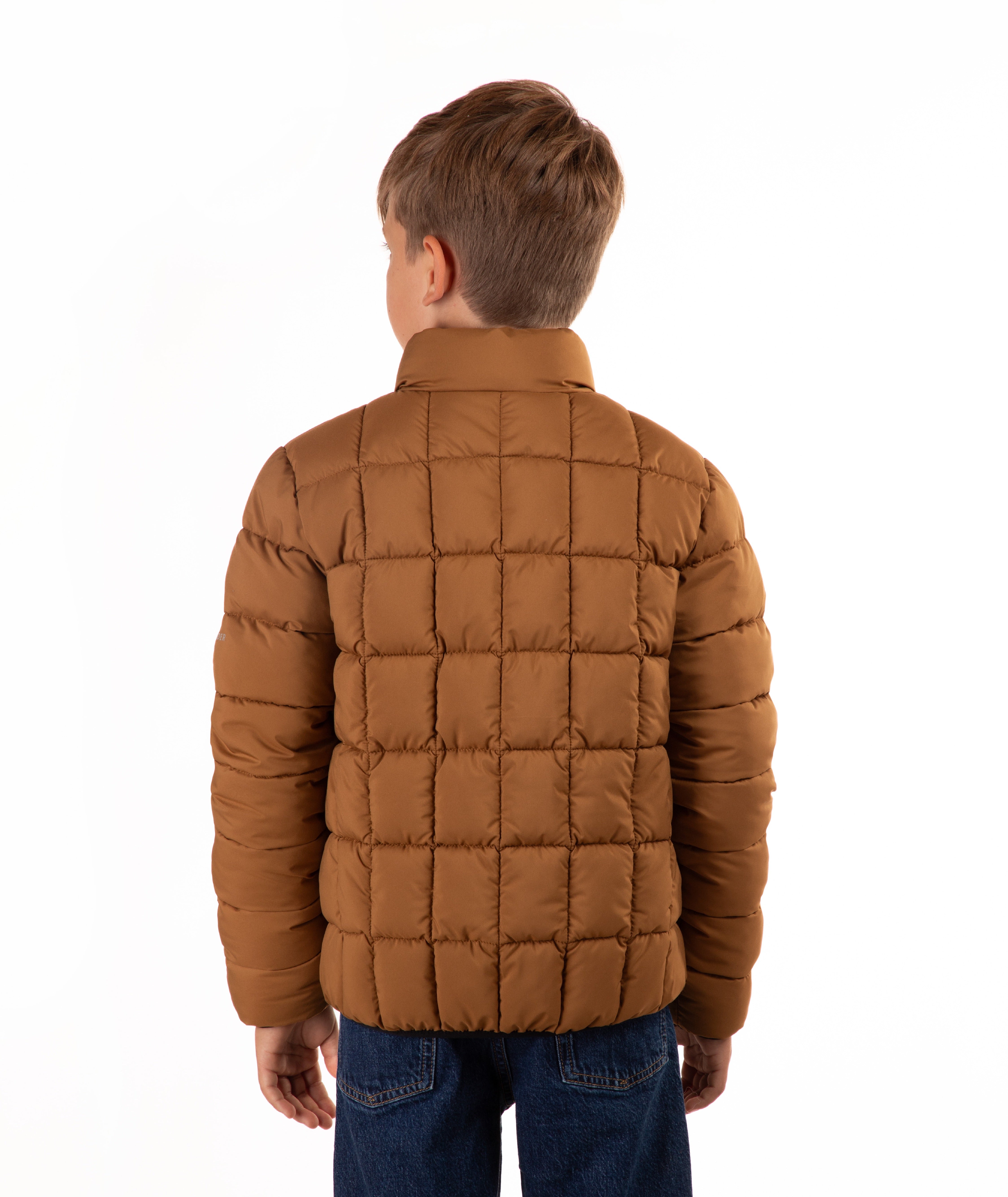 A child viewed from the back wearing a brown quilted puffer jacket and blue jeans against a plain white background.