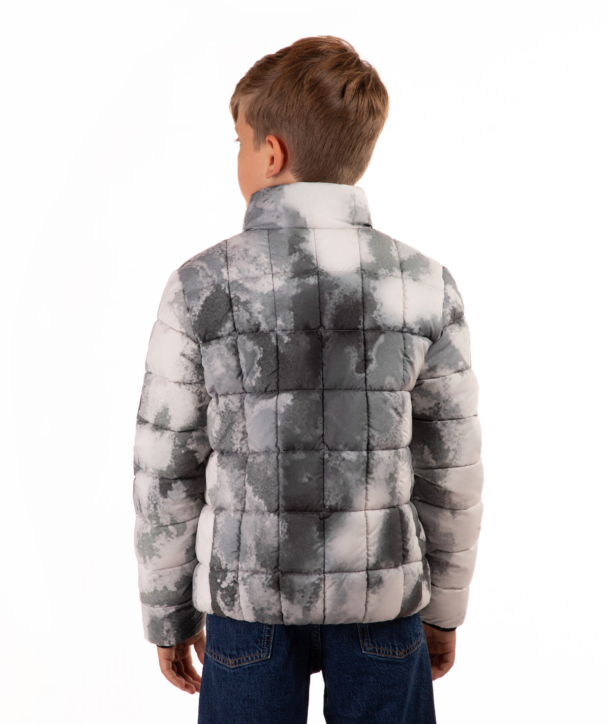 A child viewed from the back wearing a gray and white cloud-patterned puffer jacket and blue jeans, set against a plain white background.