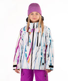 A child wearing a colorful abstract print ski jacket, a purple knit beanie, and purple ski pants, standing against a plain white studio background.