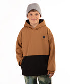 A child wearing a color-blocked hoodie with a brown upper half and black lower half, paired with a gray beanie and camouflage pants, photographed against a plain white background.