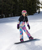 Person snowboarding on a snowy slope with trees in the background