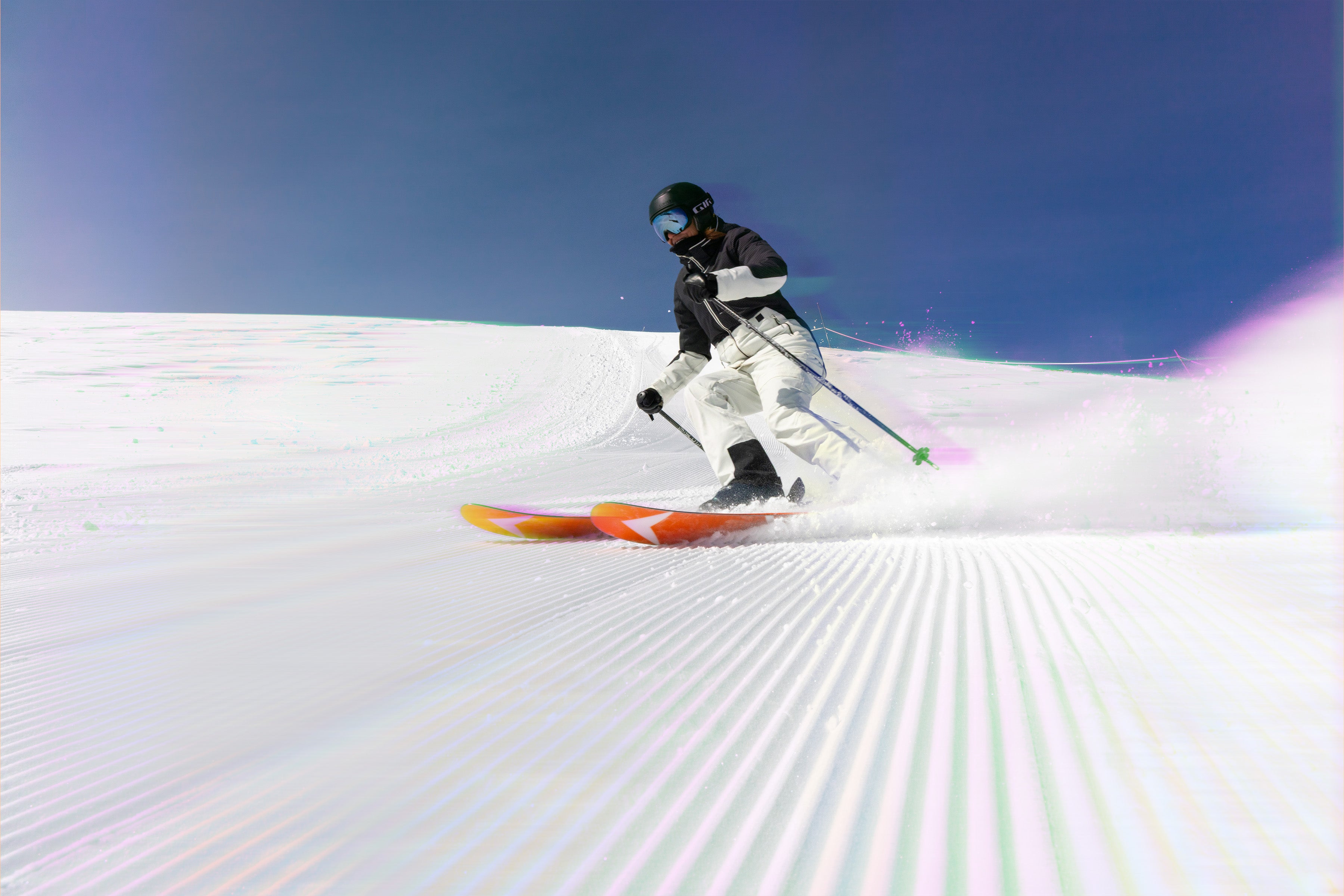 Female skier in action on a snowy slope with a clear blue sky