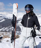Person in ski gear with skis on a snowy mountain