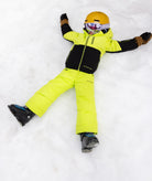 Person in bright yellow snowsuit and helmet lying on the snow