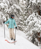 Person skiing through a snowy forest with snow-covered trees