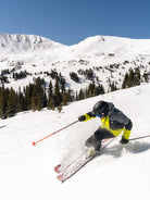 man skiing wearing a lime, gray and black jacket